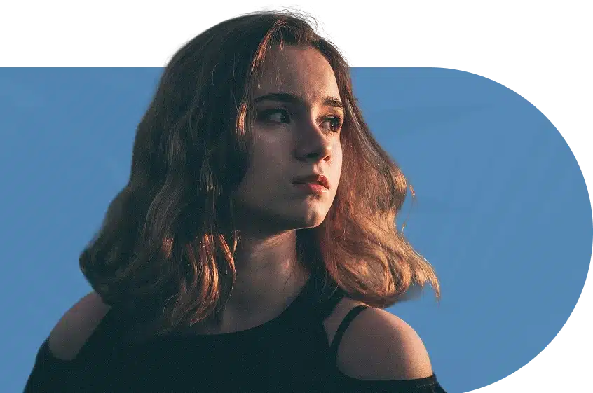 A sad girl with brown hair wearing a black top