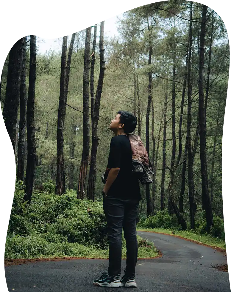 The boy in the black shirt is standing on the road